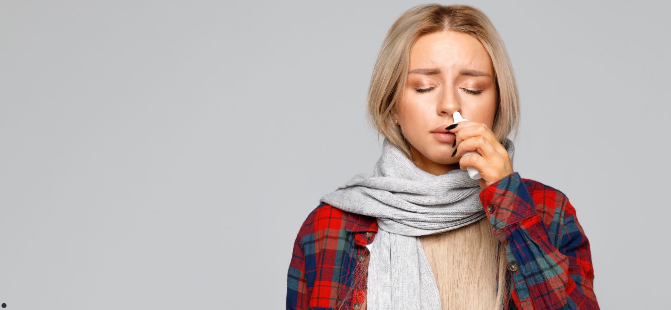 A woman using nasal spray.