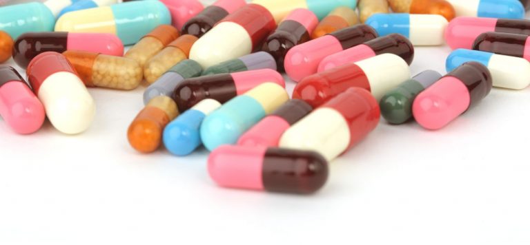 An assortment of different pills on a white background.