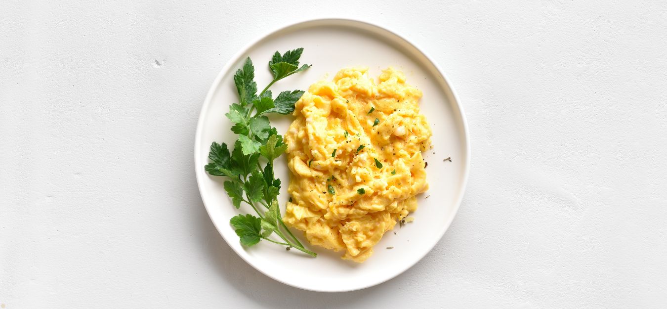 A plate of scrambled eggs on a white background.