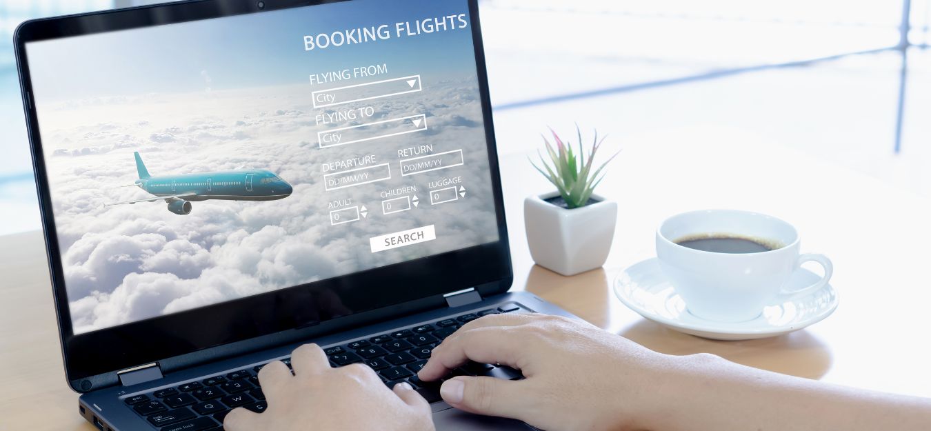 A close up of a person booking a flight on a laptop.