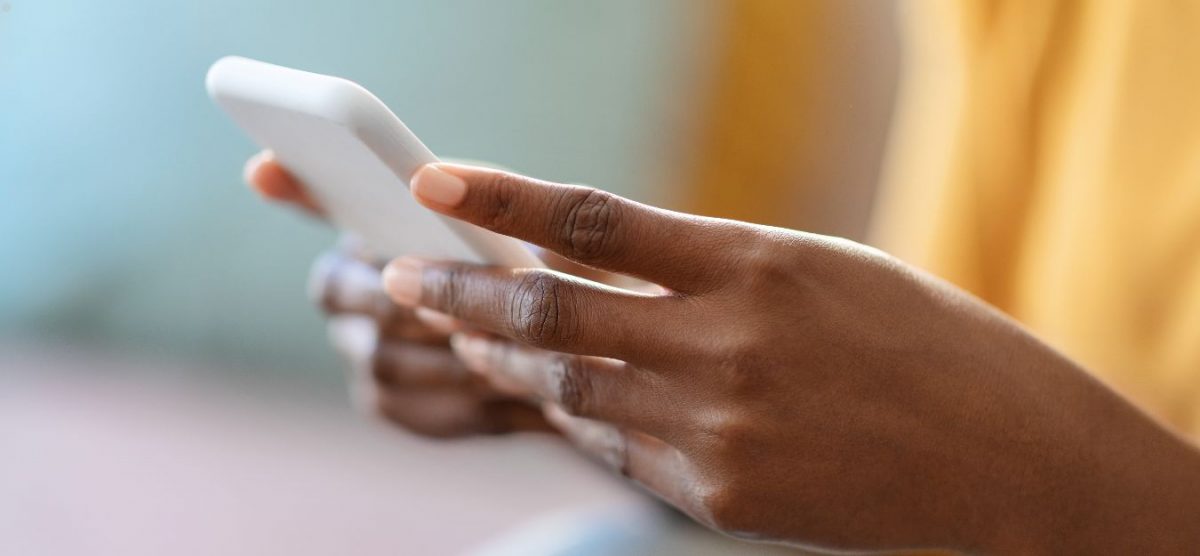 Hands holding a cell phone.