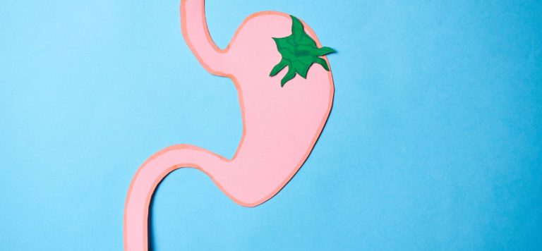 An illustration of a stomach, with a green spot signifying a tumor.