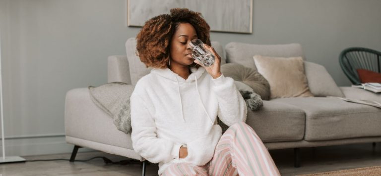 A woman drinking a glass of water.